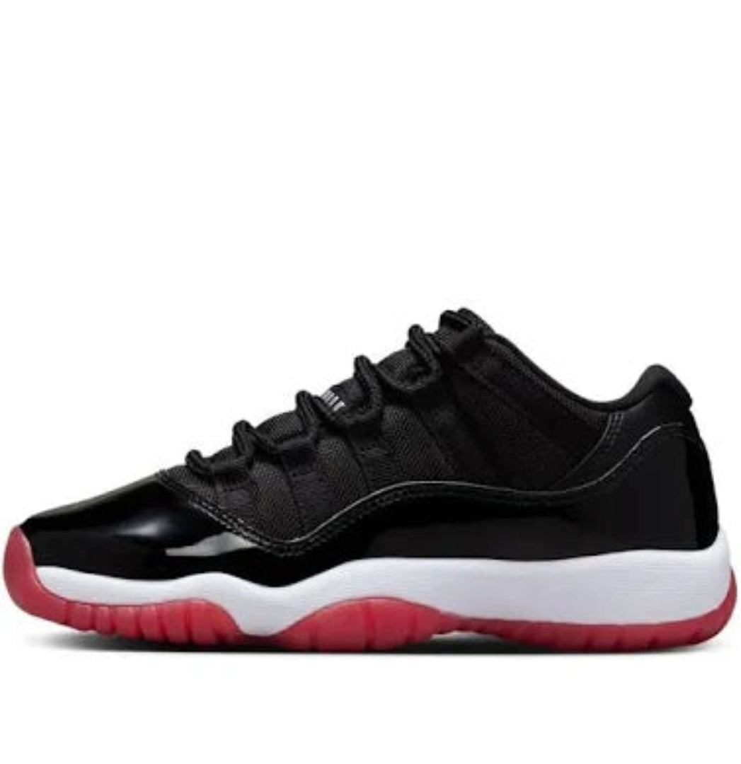 Air Jordan 11 Retro Low GS in black with patent leather overlay and varsity red outsole